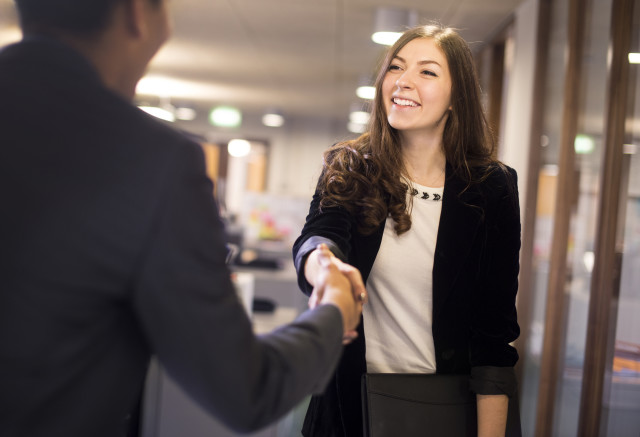 young woman shakes hands with her potential new boss
